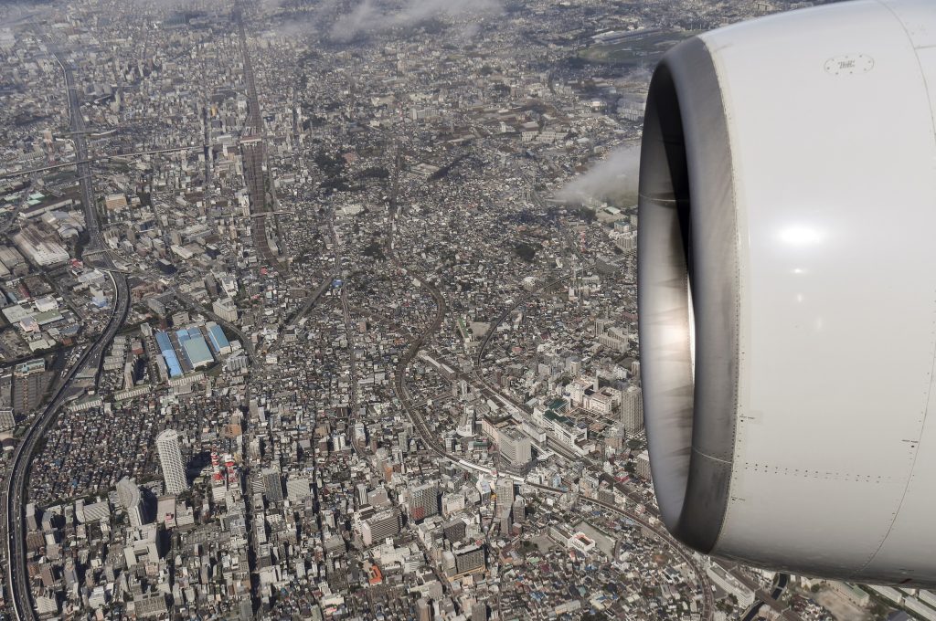 2019年9月23日、東京の羽田空港に着陸する準備をしているANAボーイング777のエンジンの下に広がる、広大な東京を空から撮影した写真。（AFP）