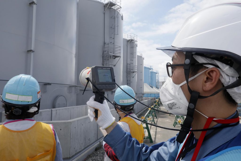 2018年7月27日に、福島県大熊町の津波で損壊した東京電力福島第一原発で、スタッフが放射線汚染水貯水タンク周辺の放射線レベルを測定する。（AFP通信）