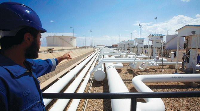リビアの港湾及びザウィヤ石油精製所の職員がパイプライン方面を指し示す。  同国の国営石油会社NOCはザウィヤ港の閉鎖を計画。 (提供/ロイター)