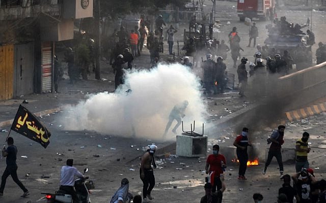 国家の汚職や公共サービスの欠陥、高い失業率に対してバグダッドのタヤラン広場でデモを行う人々に対し、催涙ガスを発射するイラク警察。（AFP）