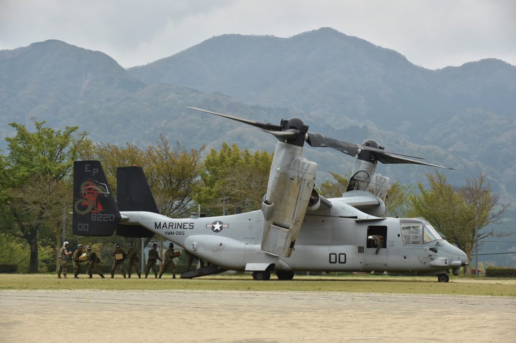 2016年4月18日、熊本県南阿蘇での救援活動の一環として、アメリカ海軍のティルトローター機のオスプレイから緊急援助物資を運ぶ日本の陸上自衛隊員。（AFP）