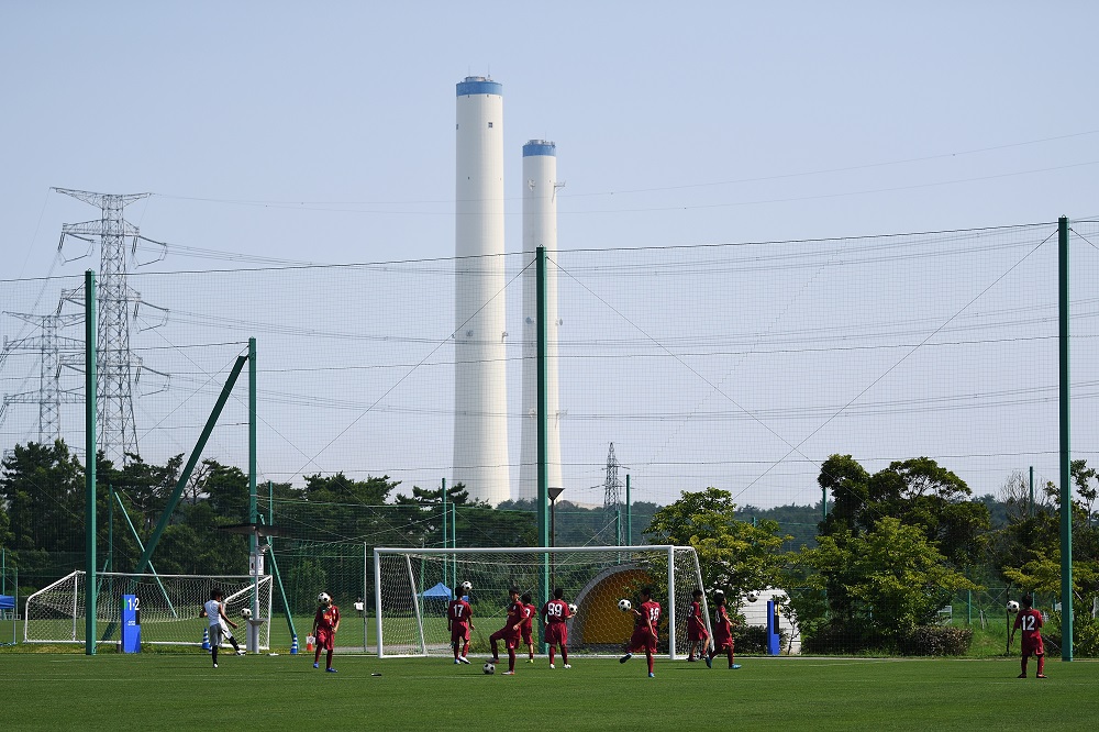 福島県楢葉町のプレスツアー開催中の2019年8月、Vヴィレッジで子供たちがサッカーをしている。 国内最大規模のスポーツ複合施設であるJヴィレッジは、1997年に設立されたが、約8年前に突然、放射線漏れとの戦いの「最前線」へと姿を変えた。（AFP/資料）