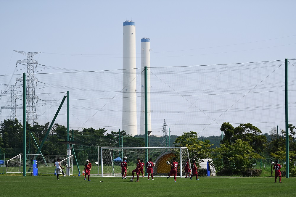 福島県楢葉町のプレスツアー開催中の2019年8月、Vヴィレッジで子供たちがサッカーをしている。 国内最大規模のスポーツ複合施設であるJヴィレッジは、1997年に設立されたが、約8年前に突然、放射線漏れとの戦いの「最前線」へと姿を変えた。(AFP/資料)