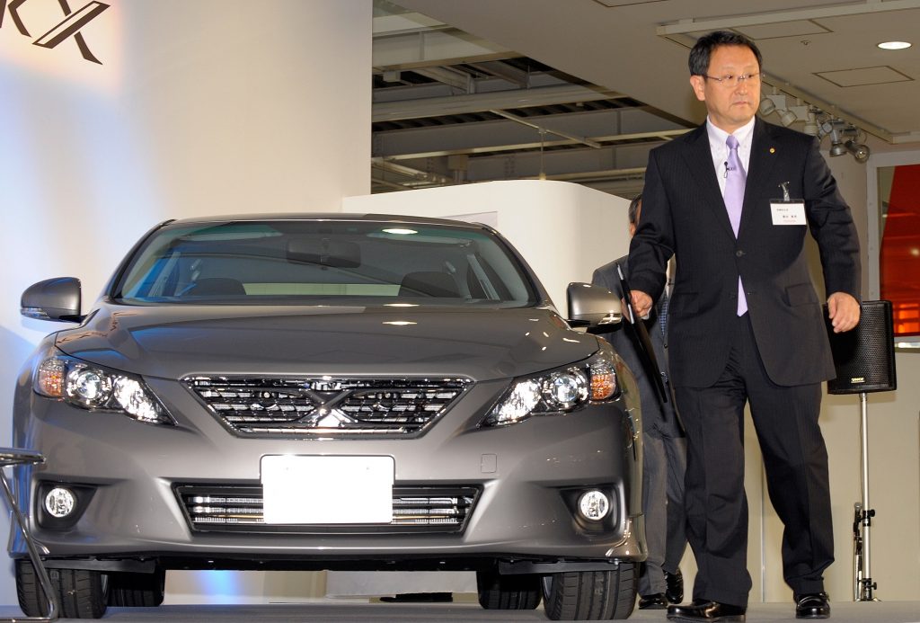 2009年10月19日、東京で開催されたプレスプレビューで、トヨタの新しいマークXセダンの横を歩くトヨタ自動車の豊田章男社長（右）。（AFP）