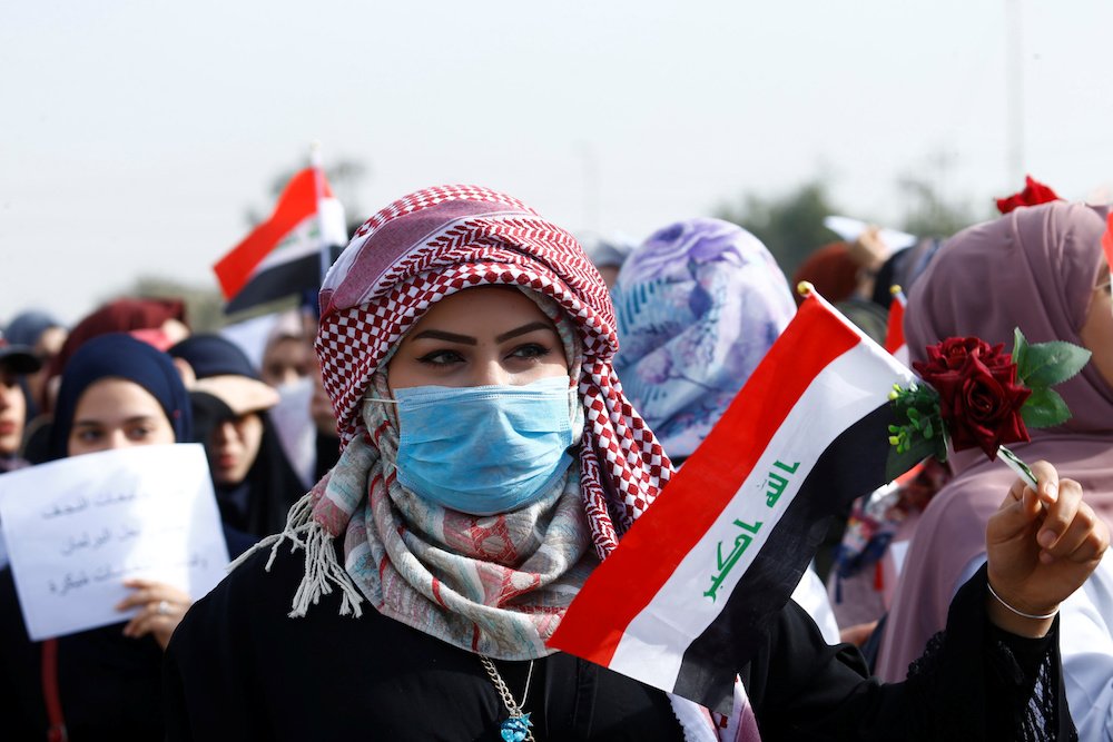 2019年12月29日、イラクのナジャフで継続中の反政府抗議行動でイラク国旗を掲げるイラク人大学生。（ロイター）