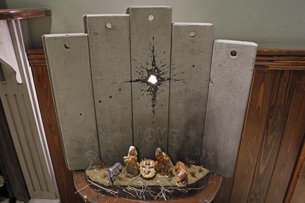 イスラエルが国際刑事裁判所で捜査されている時に、イギリスのアーティストのバンクシーによる「ベツレヘムの傷」と名付けられたクリスマスをテーマにした作品は、ベツレヘムにあるバンクシーのウォールド・オフ・ホテルで展示されている。（AFP）