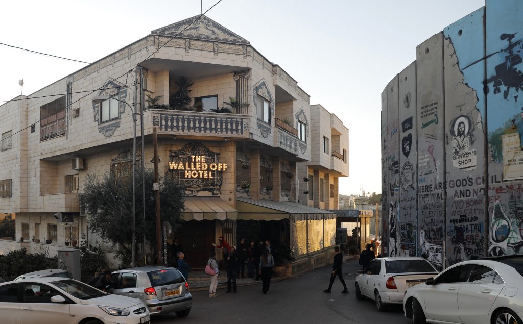 イギリスのアーティスト、バンクシーのウォールド・オフ・ホテルは、占領されたベツレヘムのウェストバンクで論争になっているイスラエルの分離壁に面している。（AFP）