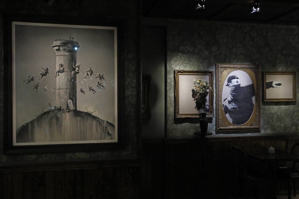ストリートアーティストのバンクシーのイラストは、占領されたベツレヘムのウェストバンクにあるウォールド・オフ・ホテルで展示されている。（AFP）