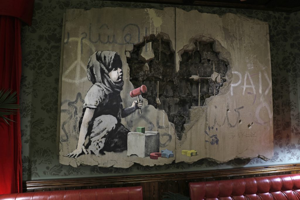 ストリートアーティストのバンクシーのイラストは、占領されたベツレヘムのウェストバンクにあるウォールド・オフ・ホテルで展示されている。（AFP）