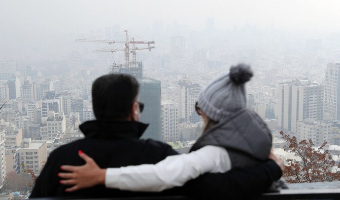 土曜日、汚染された空気に霞むテヘランを眺める人々。(AP通信)