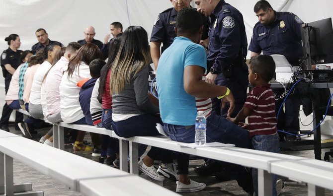 合衆国で亡命を申請した移民が、テキサス州ラレドの移民保護議定書入国聴取施設の新しいテント法廷における手続きエリアを通過している。（AP/提出資料）