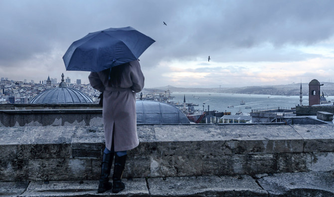 2020年1月2日、傘を持った女性が、イスタンブール市エミニョニュ地区にあるスレイマニエ・モスクのテラスから、ボスポラス海峡を眺めている様子。(AFP)