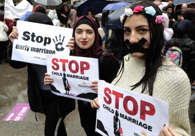 首都ベイルートで18歳以下の結婚に反対するデモに参加しながらプラカードを掲げるレバノン人女性（AFP通信）