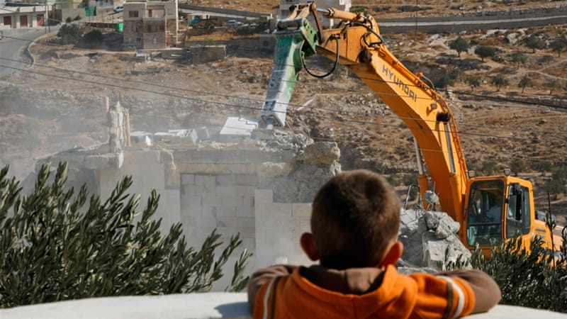 東エルサレム郊外のスルバヘルで住宅を解体する自治体職員を見る、パレスチナ人の男の子。（AP写真）