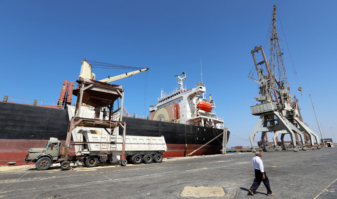 イエメン・フダイダの紅海港で、船のそばを歩み過ぎる労働者。 （ロイター）