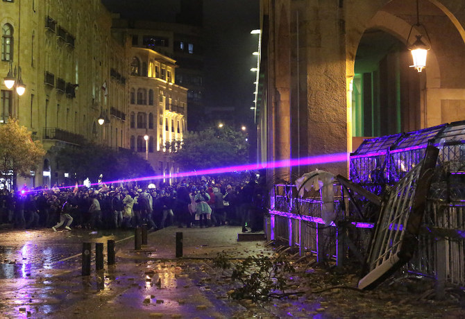 機動隊との衝突でレーザー光を照射する反政府抗議者。（AP）