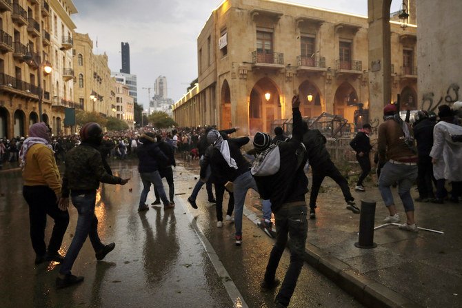 2020年1月18日土曜日、レバノン、ベイルートの国会議事堂へ続く道路での抗議活動で、反政府抗議者たちが機動隊と対立している。機動隊は何千もの人々を追い散らすために、国会議事堂付近で催涙ガスや放水銃を放った。（AP通信）