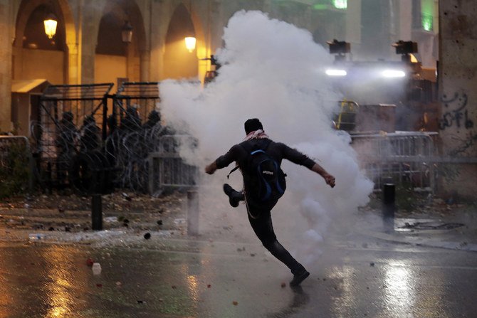 2020年1月18日土曜日、レバノン、ベイルートの国会議事堂へ続く道路での抗議活動で、反政府抗議者たちが機動隊と対立している。機動隊は何千もの人々を追い散らすために、国会議事堂付近で催涙ガスや放水銃を放った。（AP通信）