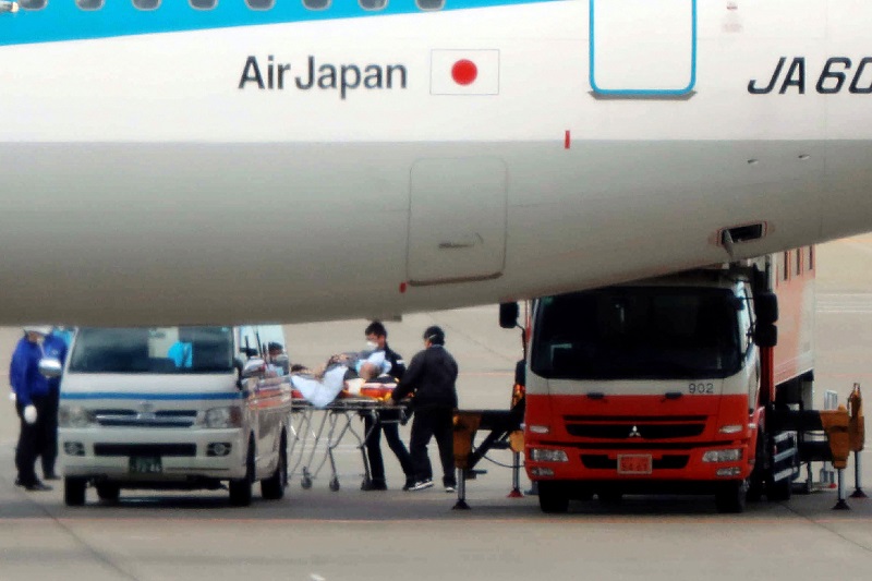 中国の都市武漢からチャーター機の第3便が到着した後、1人の乗客がストレッチャーで運ばれた。同便は日本政府が邦人を退避させるために手配した便で、2020年1月31日に東京の羽田空港に到着した。（AFP）
