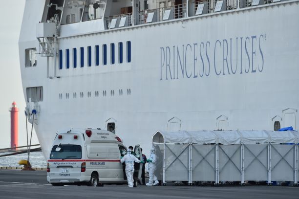 クルーズ船「ダイヤモンド・プリンセス」に入る防護服を着た人たち=10日午後、横浜市の大黒ふ頭。(AFP)