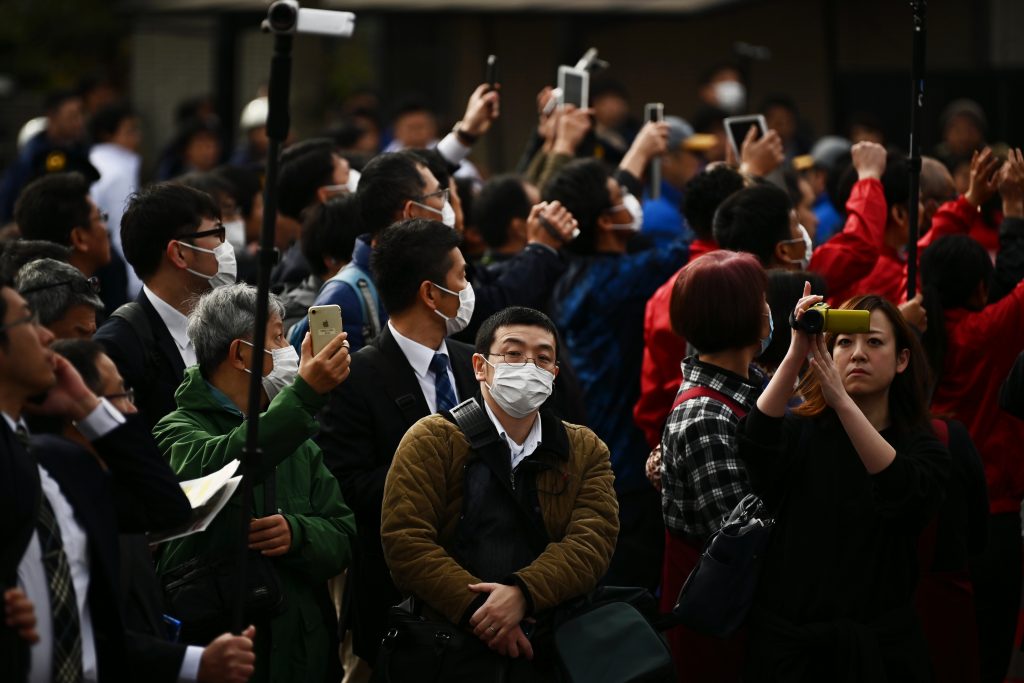 2020年2月15日、東京2020オリンピック大会聖火リレーのリハーサルを見学するマスク姿の人々（AFP通信）