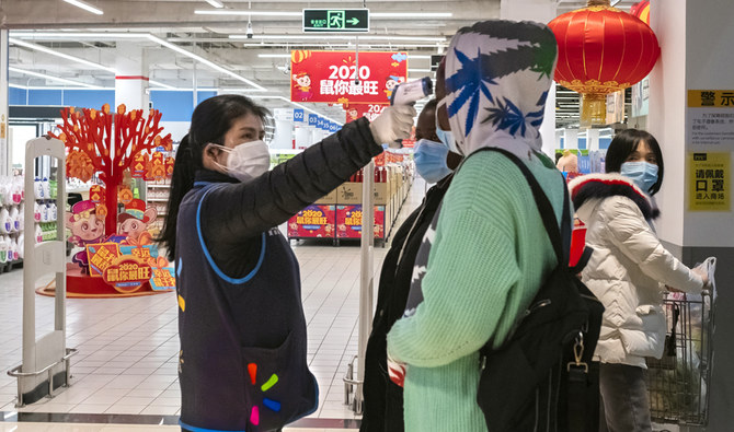 中国・湖北省中部の武漢にあるウォルマートの店舗入口で、客の体温を測る従業員。(AP)