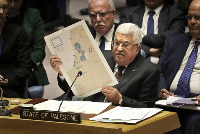 マフムード・アッバスは、「スイスチーズ」のようなをパレスチナ領土を作る米国による中東和平計画の地図を掲げる。（AP）