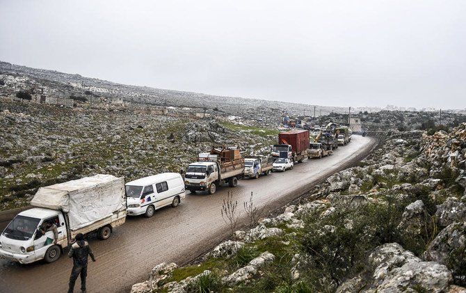 アサド軍による攻撃の中、トルコとの国境付近のシリア国内で安全な場所を見つけるため、雨の中イドリブから北へと避難するシリア国民。2020年2月13日。（写真：AP）