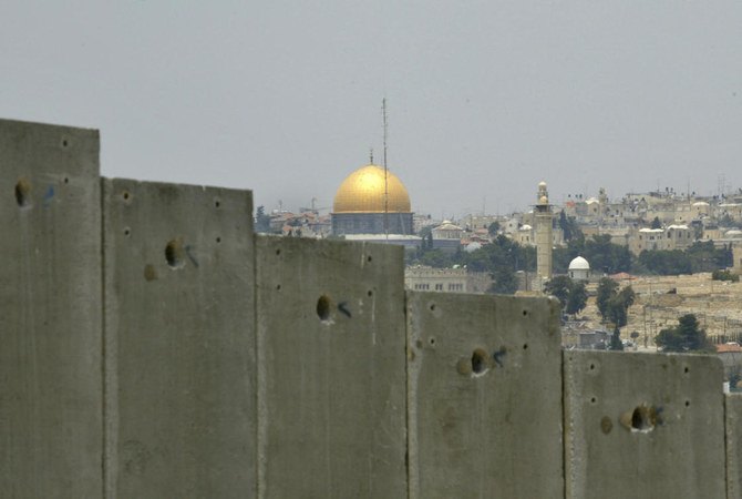 この2004年7月9日の資料写真は、エルサレム旧市街のドームにある黄金の聖堂が、エルサレム郊外のアブディス村でイスラエルが建設していて物議を醸している分離壁のコンクリートの壁で構成された区域の背後に見えることを示している。（AP）