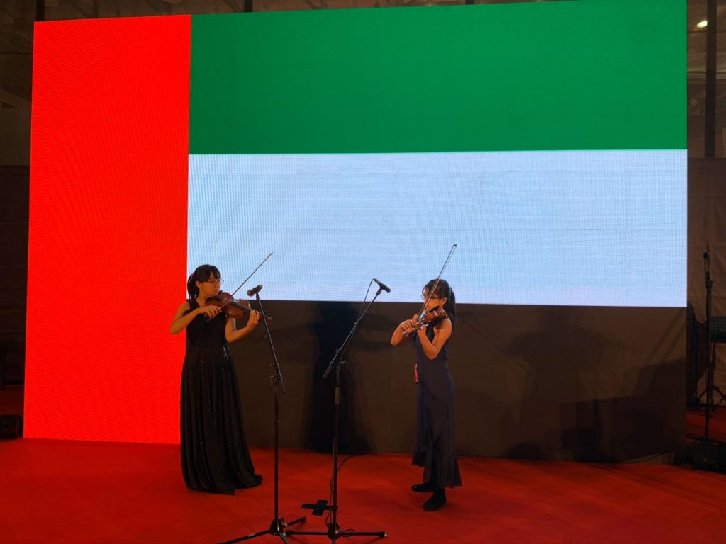 中東ユース・エキスポ2020でアラブ首長国連邦の国歌をバイオリンで演奏するウメザワ姉妹。（提供）