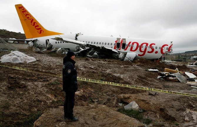着陸時にイスタンブールのサビハ・ギョクチェン空港の滑走路をオーバーランして大破したペガサス航空ボーイング737-86Jの機体のそばで、係官が見張りをする。（ロイター通信）