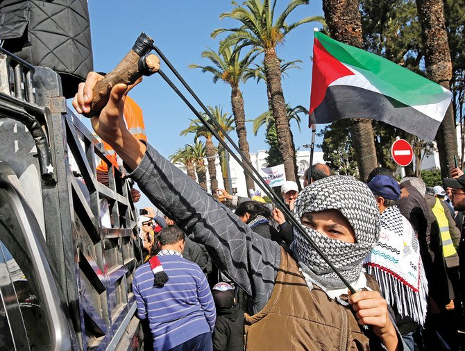 デモ隊の一人が米国の中東和平案への抗議活動中、空のスリングショットでポーズを取っている。9日、モロッコ・ラバトで。（ロイター）