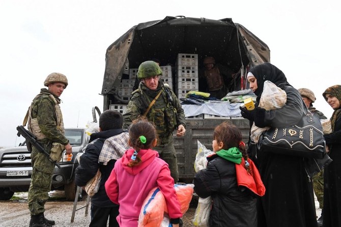 9年間に及ぶ紛争でそれぞれ敵対する陣営を支援しているトルコとロシア。上の写真では、ロシア兵らがシリアの民間人に食糧援助物資を配布している。（AFP通信）