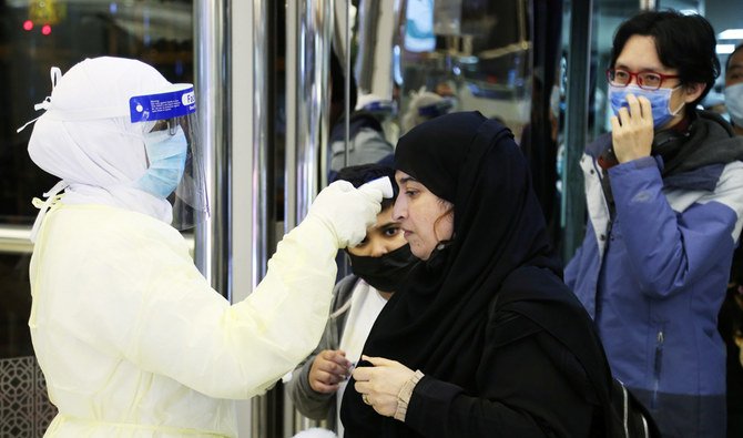 新コロナウイルスを防ぐためにマスクをして中国から入国した乗客が、サウジアラビアのリヤドにあるキング・ハーリド国際空港に到着した際、サウジアラビア保健省の職員によって検査される様子。2020年1月29日。（ロイター）