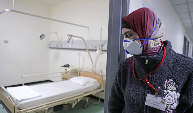 2020年2月22日、首都ベイルート南部郊外のラフィク・ハリリ大学病院で、国内初のコロナウイルス感染者が治療を受けた病棟のベッドを見る防護マスクを着けたレバノン人職員。(AFP)