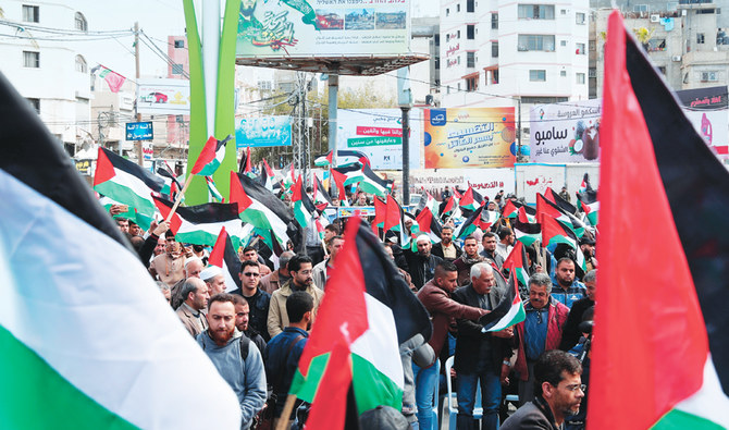 金曜日、ガザ市の主要道路で正午の祈りの後、パレスチナ人が米国の中東和平案に対する抗議デモで国旗を振りかざす。 （AP）