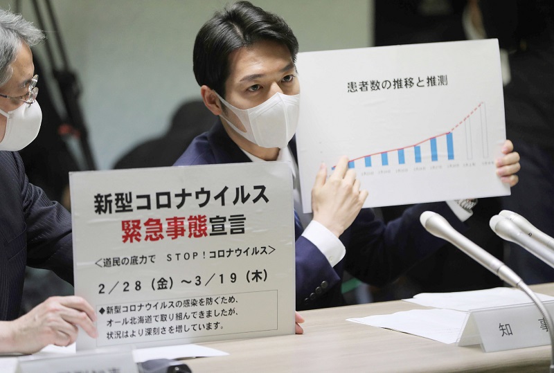 2020年2月28日に北海道の鈴木直道知事（右）が、北海道で開催された新型コロナウイルス感染症（COVID-19）に関する会議で緊急事態宣言を発令する。（AFP）