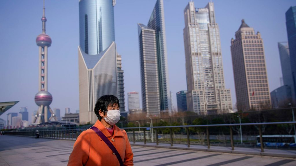  武漢でのコロナウイルス流行を受け、上海浦東の金融街・陸家嘴をマスク姿で歩く女性。（ロイター）