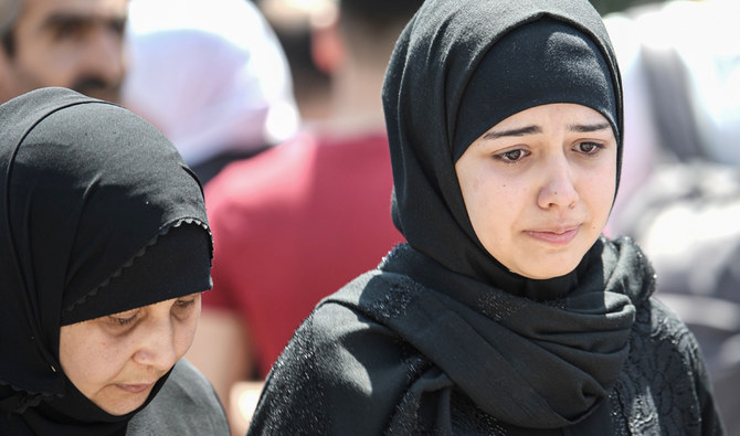 シリアの難民が自発的にバスに乗って近隣のシリアに戻る際、家族や友人たちが別れを告げる様子。イスタンブールのエセンユルト地区にて。2019年8月6日（AFP）
