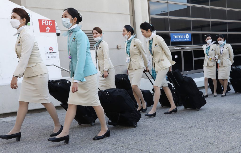 2020年2月28日にカリフォルニア州ロサンゼルスのロサンゼルス国際空港（LAX）に到着後、大韓航空のフライト乗務員たちの多くが保護マスクを着けて国際ターミナルを出ていく。（AFP通信）