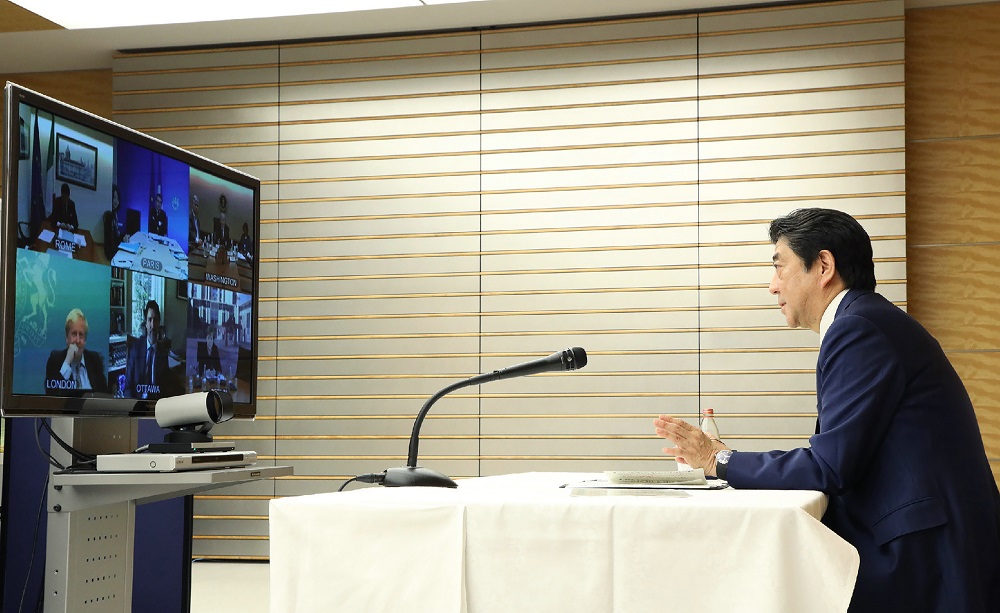 日本の内閣広報室が提供し、時事通信社が公開したこの配布資料の写真では、2020年3月16日に行われたテレビ会議で、安倍晋三首相（右）が東京から他のG7の指導者らと会談をしている。(AFP/file)