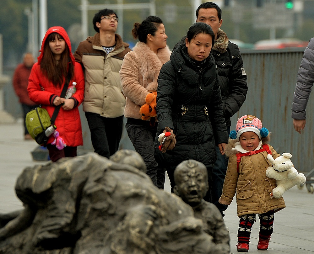南京の南京大虐殺記念館にて、日本の戦争犯罪による犠牲者の慰霊碑のそばを歩く中国人観光客。昨年の訪日外国人のうち約950万人が中国人で、過去7年間で6倍以上増加している。（AFP /ファイル）
