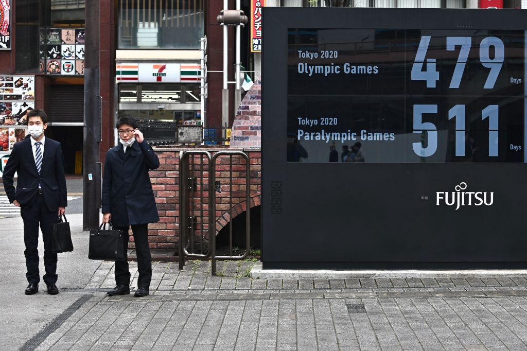 東京の地下鉄駅前で東京2020オリンピックとパラリンピックまでの日数を表示するカウントダウン時計。2020年3月31日。（AFP）