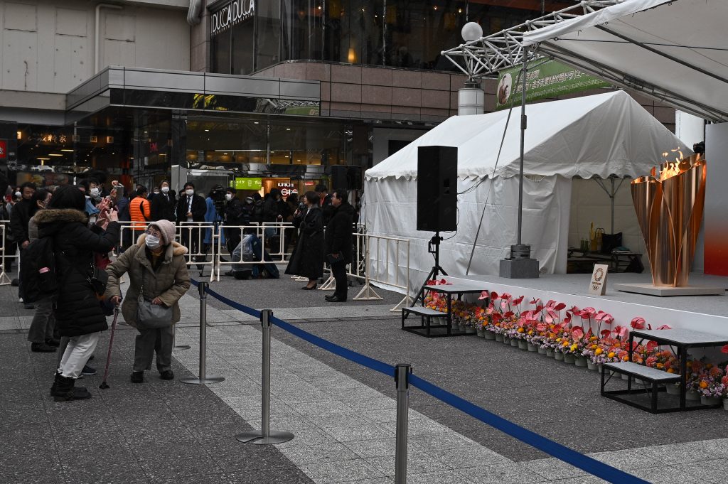 福島の駅構外に公に展示された東京2020オリンピックの聖火を観るために集まった人々。2020年3月24日。(AFP)