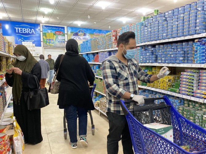 防護マスクを着用したリビア人たちが、首都トリポリのスーパーマーケットで買い物をしている。戦争で荒廃したこの国が、新型コロナウイルスの症例を初めて報告した。（AFP資料写真）