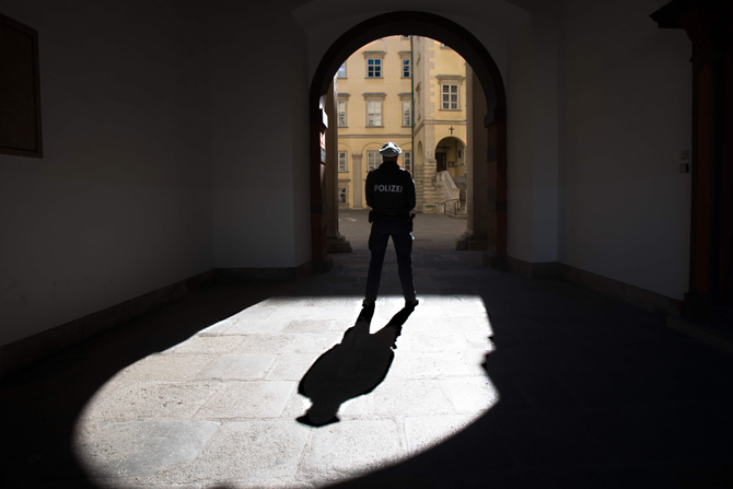 コロナウイルスでオーストリアが5人以上の集会を禁止した中、同国のウィーンのホーフブルク王宮の通路に立つ警察官。（AFP）