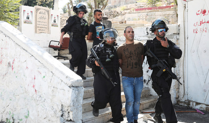 東イスラエルのイサウィヤでの衝突でイスライエル警察に逮捕される2名のパレスチナ人 (AP/Fファイル)