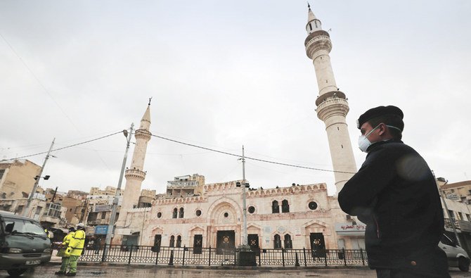 20日、コロナウイルスの病気拡大への懸念の中、アンマンにあるアル＝フサイニー・モスクが礼拝者に対して閉じられた後、その前で番をするヨルダンの警察官。（ロイター）