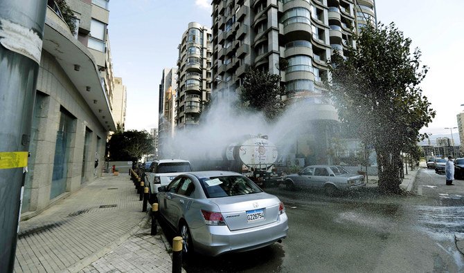  新しいコロナウイルスの拡散に対する政府のキャンペーンの一環として、土曜日にベイルートの街頭で自治体職員が消毒剤を散布した。（AFP通信）