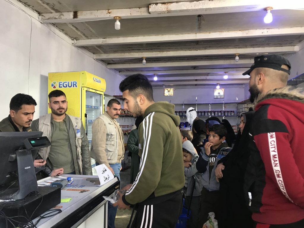 避難民はキャンプ内の店での食品購入に使用できる電子バウチャーを受け取る。（ツイッター/@WFP_Iraq）